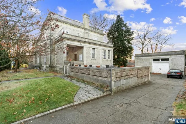 a view of a white house with a big yard and large tree