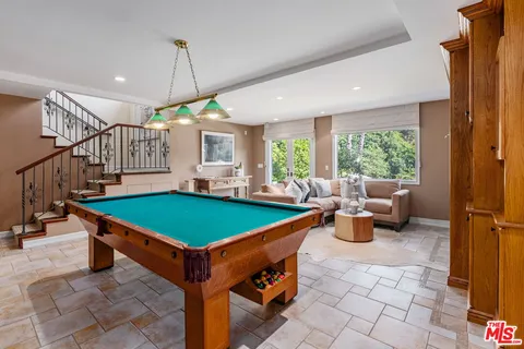 a room with pool table and windows