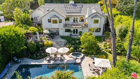 a front view of a house with a yard and fountain