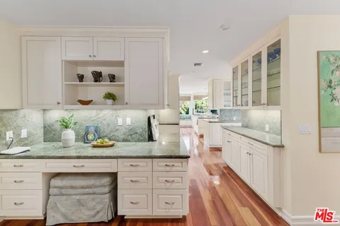 a kitchen with granite countertop white cabinets and white stainless steel appliances
