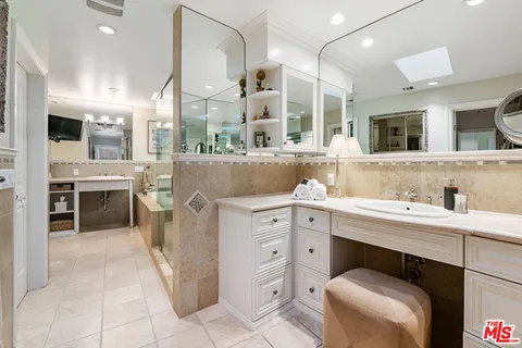 a spacious bathroom with a double vanity sink and a mirror