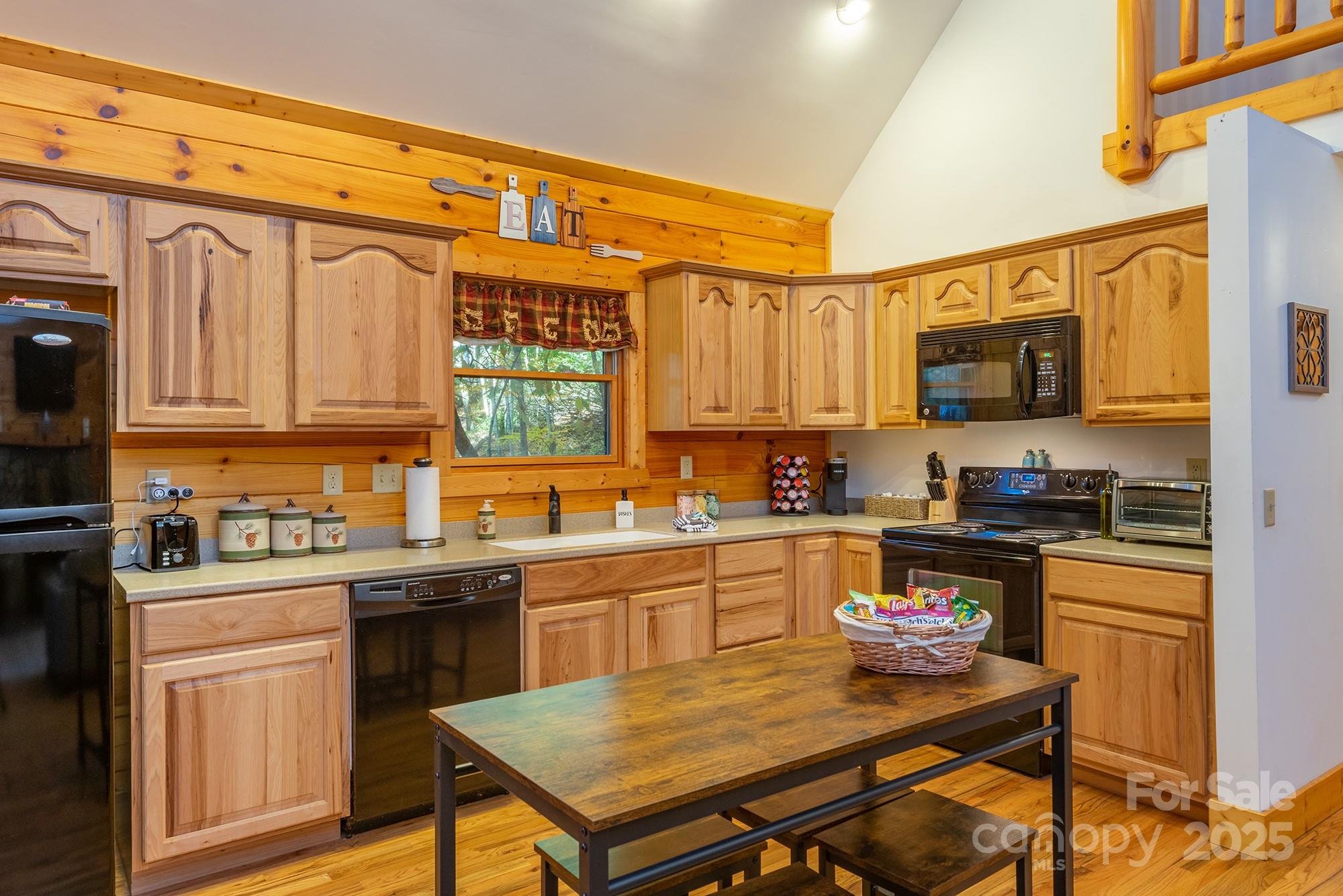 100 Candlemaker Trail Maggie Valley, NC 28751 - Photo 11 of 34 a kitchen with a sink a stove and chairs