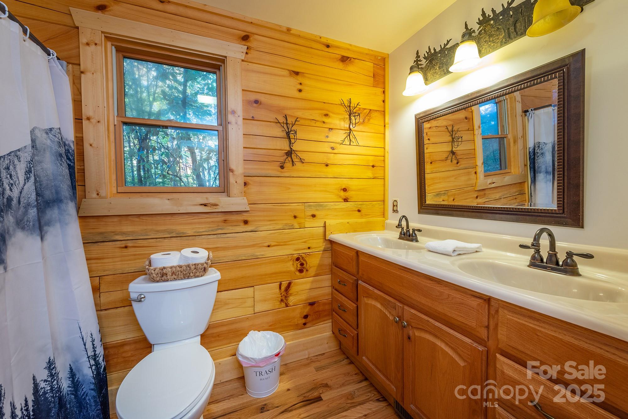 100 Candlemaker Trail Maggie Valley, NC 28751 - Photo 16 of 34 a bathroom with a granite countertop toilet sink and a large mirror