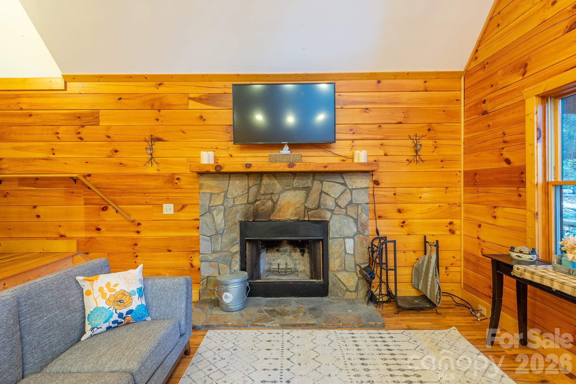 100 Candlemaker Trail Maggie Valley, NC 28751 - Photo 5 of 34 a living room with a fireplace and a flat screen tv