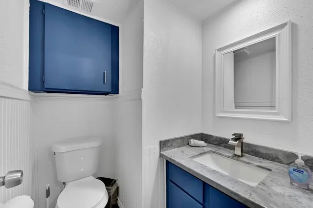 a bathroom with a toilet sink and mirror