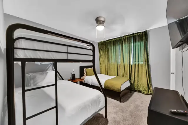 a bedroom with a bed window and a flat screen tv