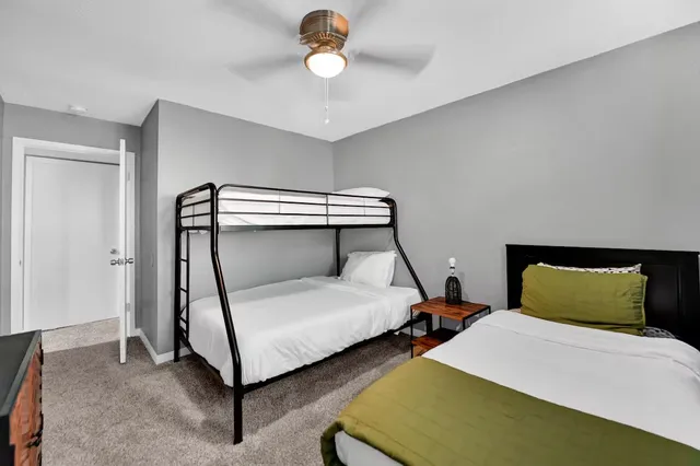 a bedroom with two beds and ceiling fan