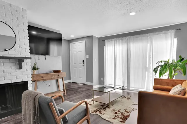 a living room with furniture a fireplace and a window