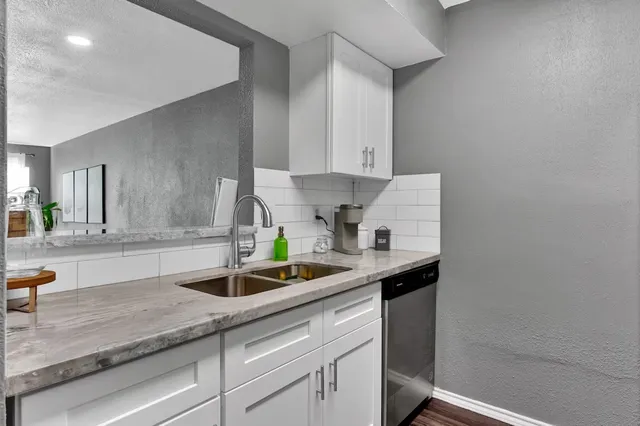 a kitchen with stainless steel appliances granite countertop a sink and a white cabinets