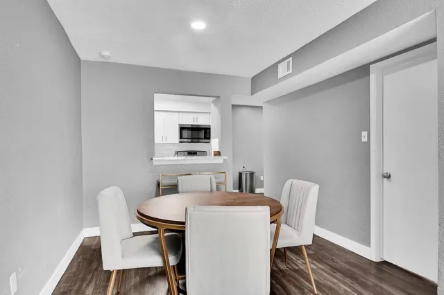 a kitchen with a table chairs and a wooden floor