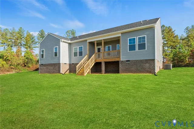 a front view of house with yard and trees in the background