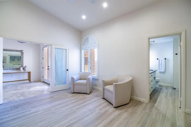 a bathroom with a granite countertop toilet a sink a mirror a bathtub and next to a window