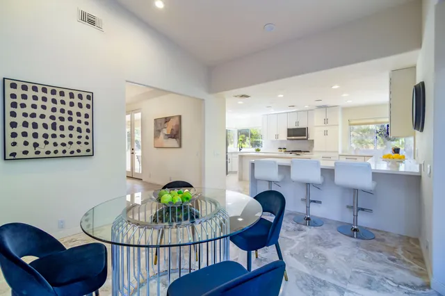 a view of a patio with table and chairs with wooden floor and fence