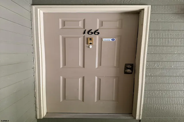 a view of a hallway with cabinet and door