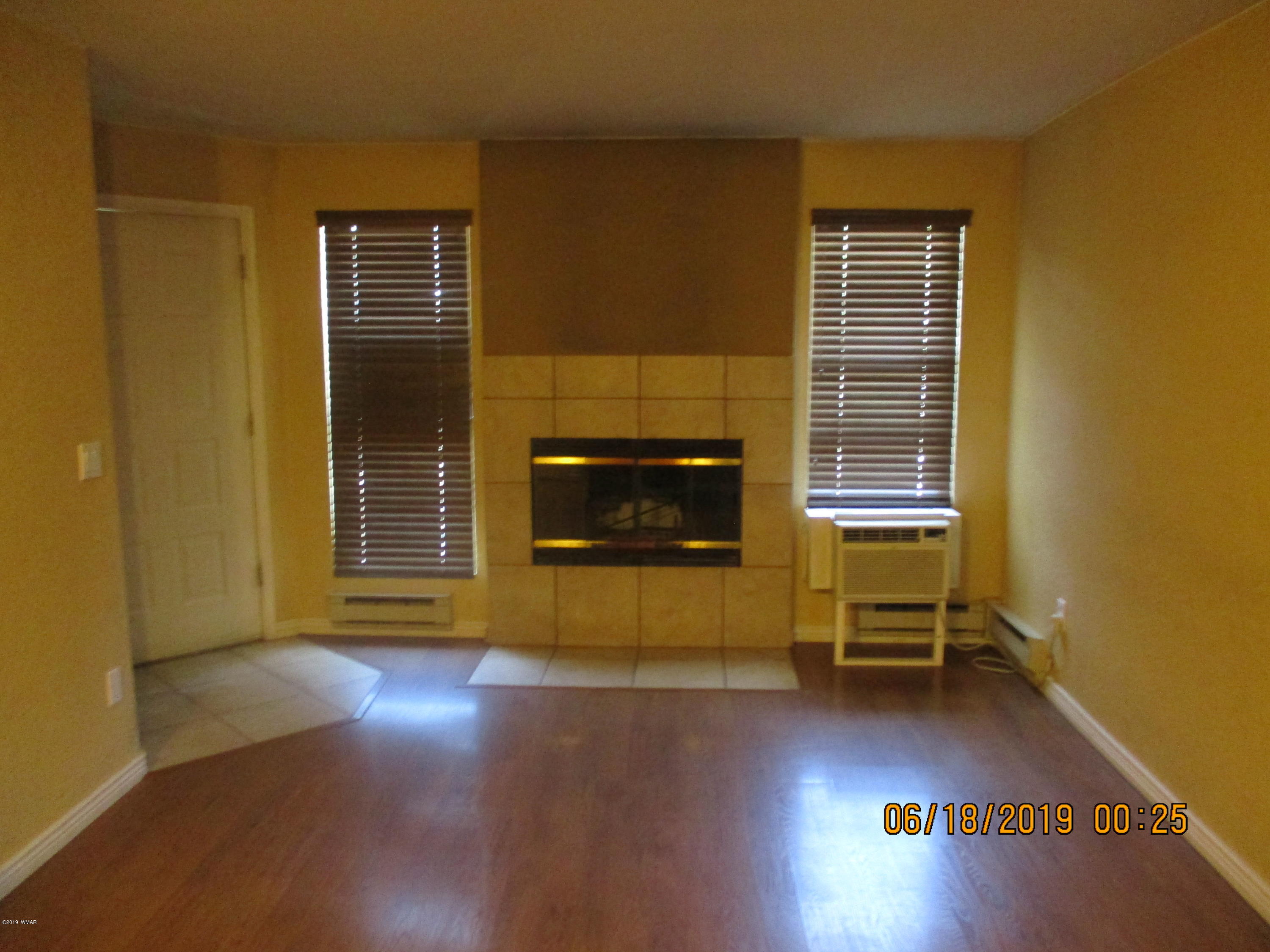 2700 South White Mountain Road, Unit 522 Show Low, AZ 85901 - Photo 2 of 8 a living room with furniture and a fireplace