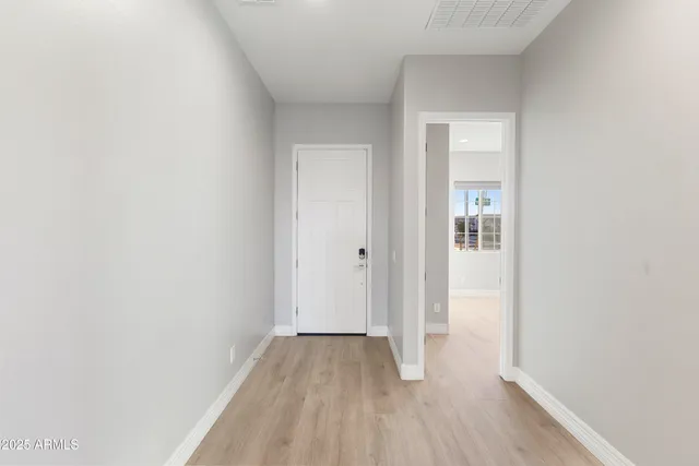 a view of a room with wooden floor and a hallway
