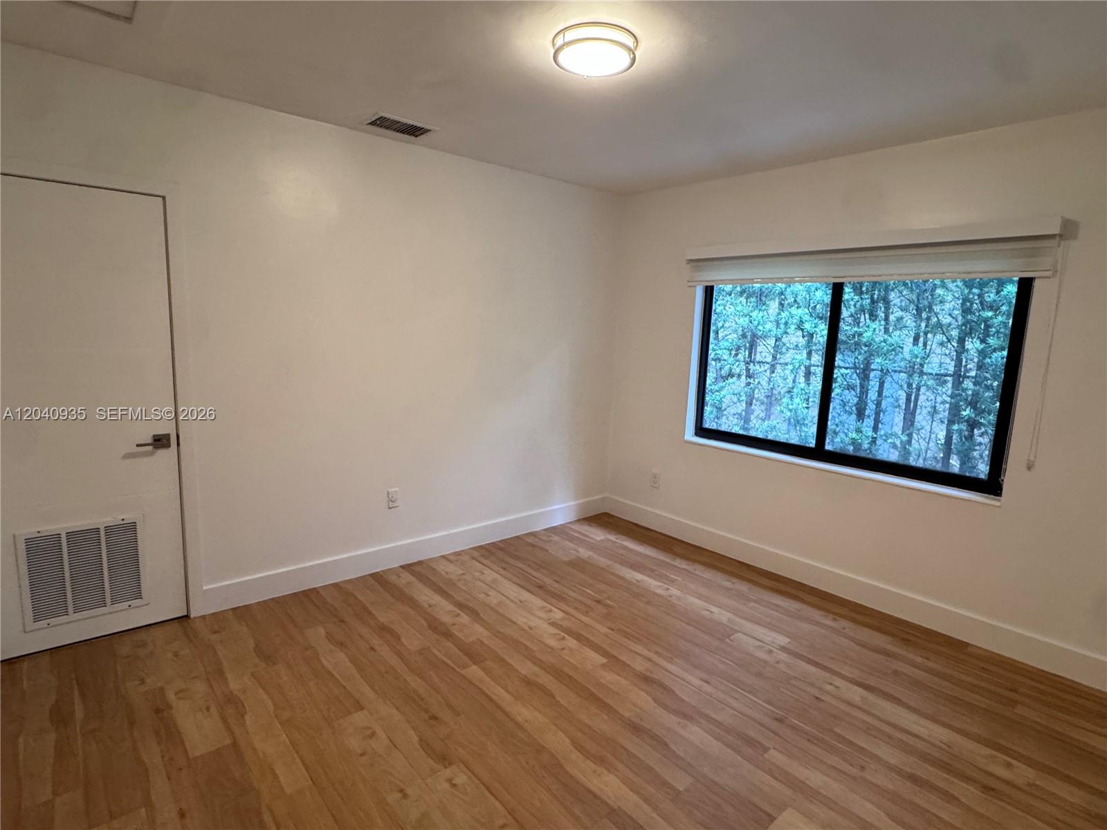 375 Southwest 32nd Road Miami, FL 33129 - Photo 38 of 44 an empty room with wooden floor and windows