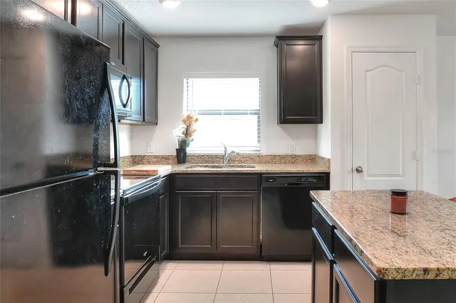 a kitchen with granite countertop a sink and a stove