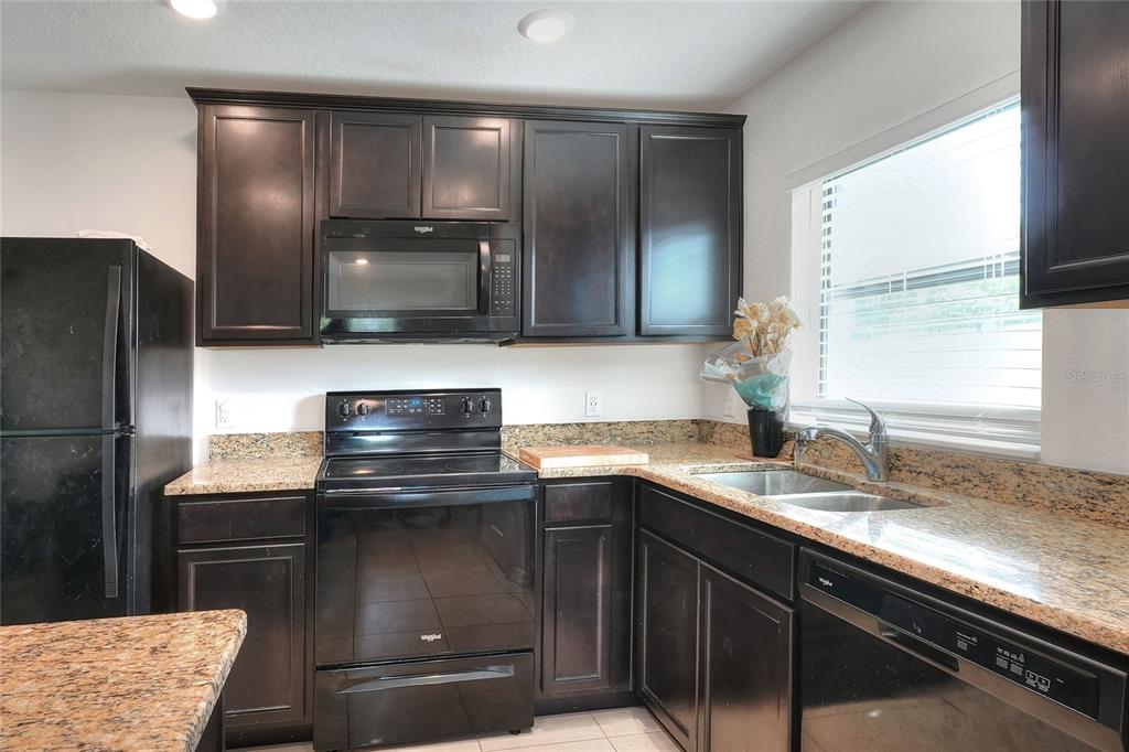 2166 Mandarin Loop Dundee, FL 33838 - Photo 13 of 44 a kitchen with granite countertop a sink and a stove