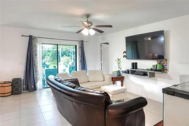 a living room with furniture a ceiling fan and a window