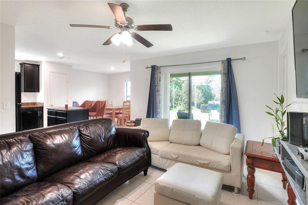 2166 Mandarin Loop Dundee, FL 33838 - Photo 10 of 44 a living room with furniture a ceiling fan and a window