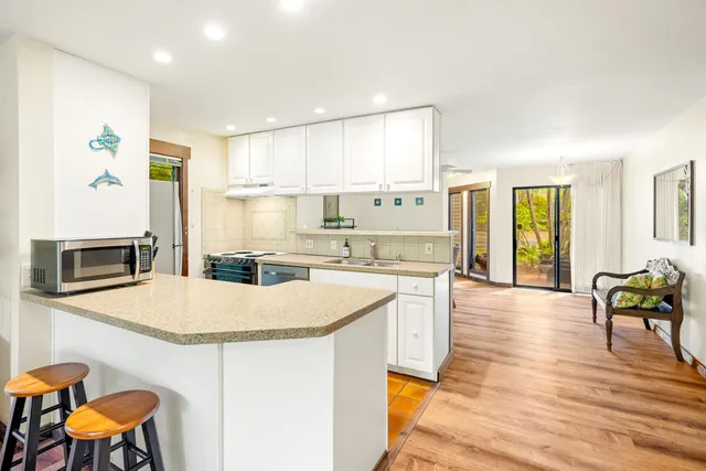 a kitchen with kitchen island granite countertop a stove and a sink