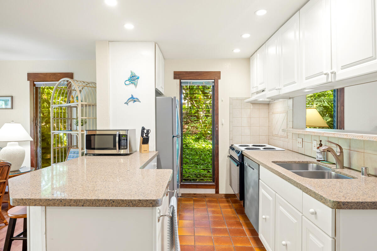 2721 Poipu Road, Unit 100 Koloa, HI 96756 - Photo 10 of 26 a kitchen with kitchen island granite countertop a stove and a sink