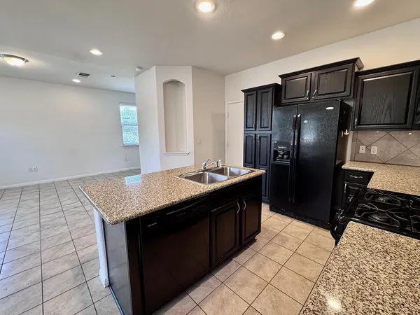 a kitchen with stainless steel appliances a refrigerator and a stove top oven