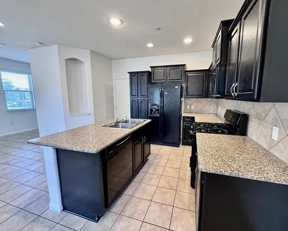 a kitchen with stainless steel appliances granite countertop a refrigerator a sink and dishwasher