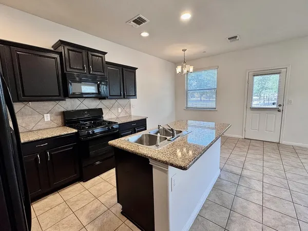 a kitchen with granite countertop cabinets and refrigerator