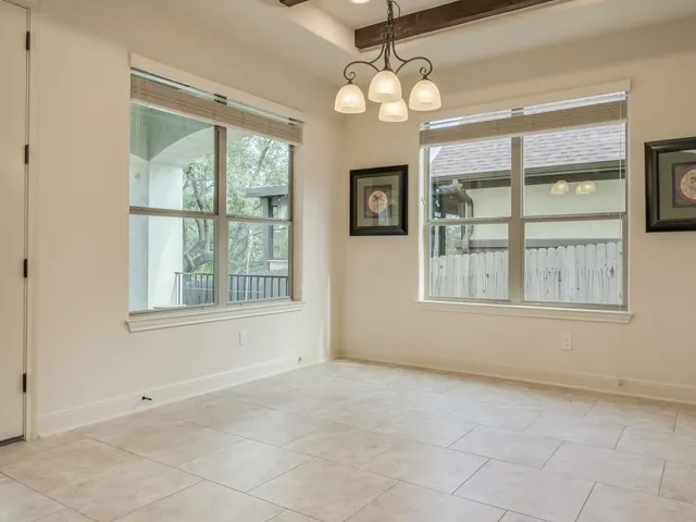 a view of an empty room with a ceiling fan and wooden floor