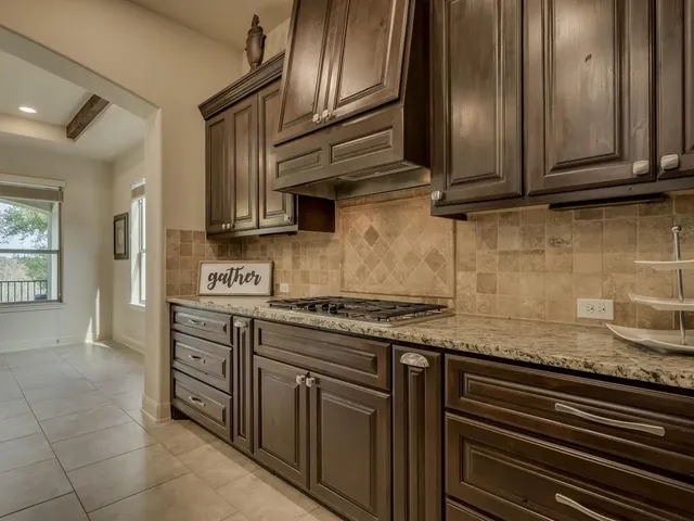 a kitchen with granite countertop a sink stove and cabinets