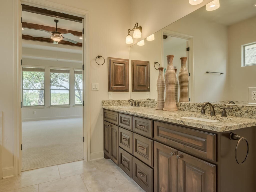 12912 Schleicher Trail Austin, TX 78732 - Photo 22 of 39 a bathroom with a granite countertop sink mirror and double
