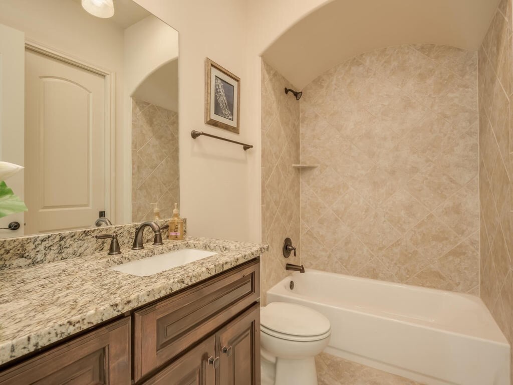12912 Schleicher Trail Austin, TX 78732 - Photo 24 of 39 a bathroom with a granite countertop sink a toilet and bathtub