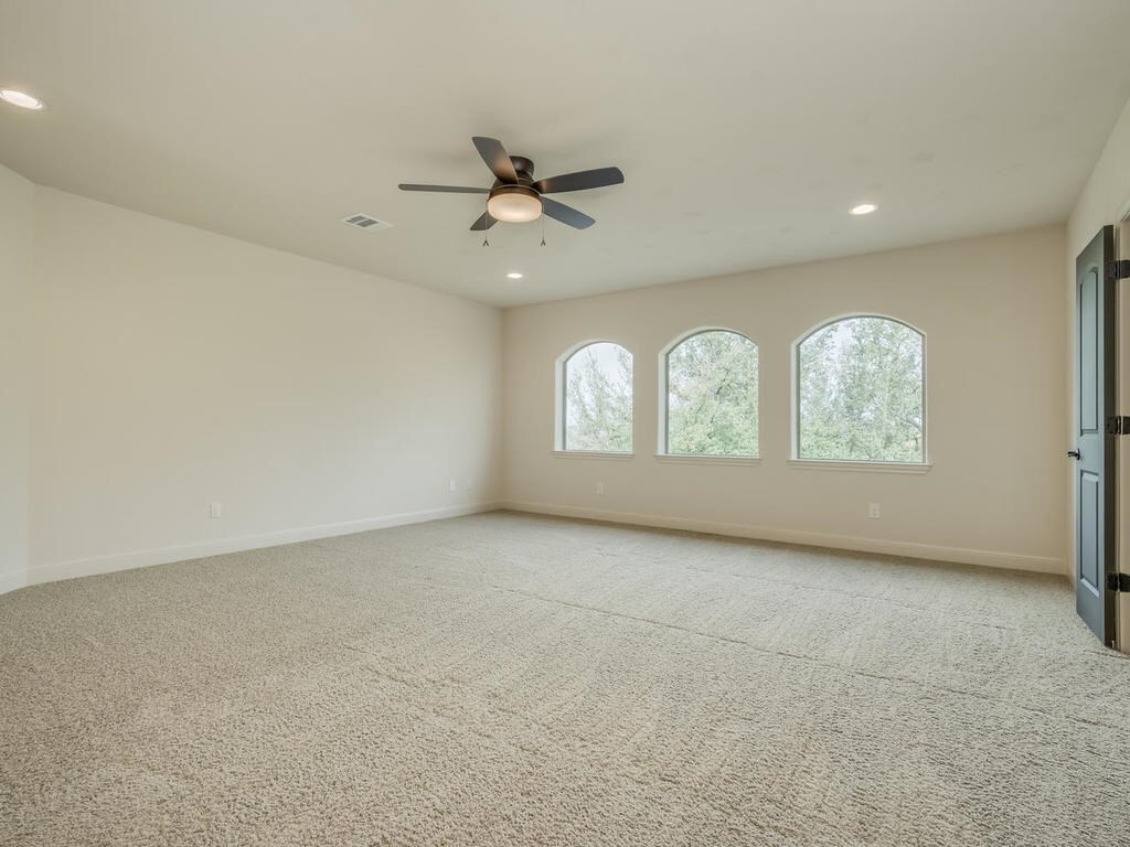 12912 Schleicher Trail Austin, TX 78732 - Photo 25 of 39 an empty room with windows chandelier fan and windows