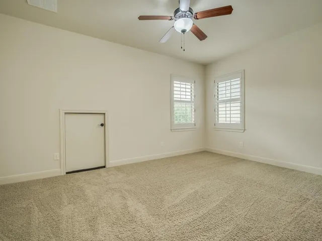 an empty room with a window and a fan