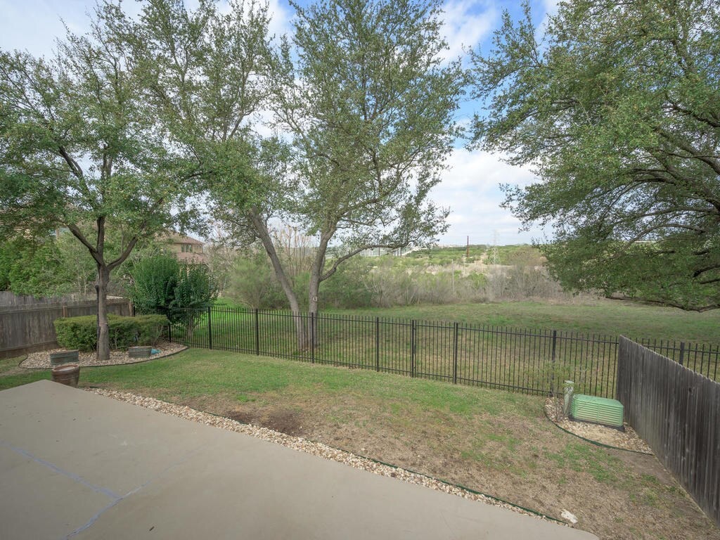 12912 Schleicher Trail Austin, TX 78732 - Photo 33 of 39 a backyard of a house with lots of green space