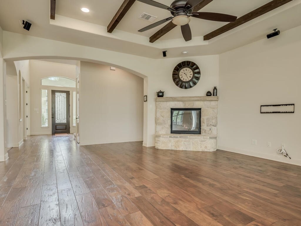 12912 Schleicher Trail Austin, TX 78732 - Photo 9 of 39 a view of an empty room with a ceiling fan and wooden floor