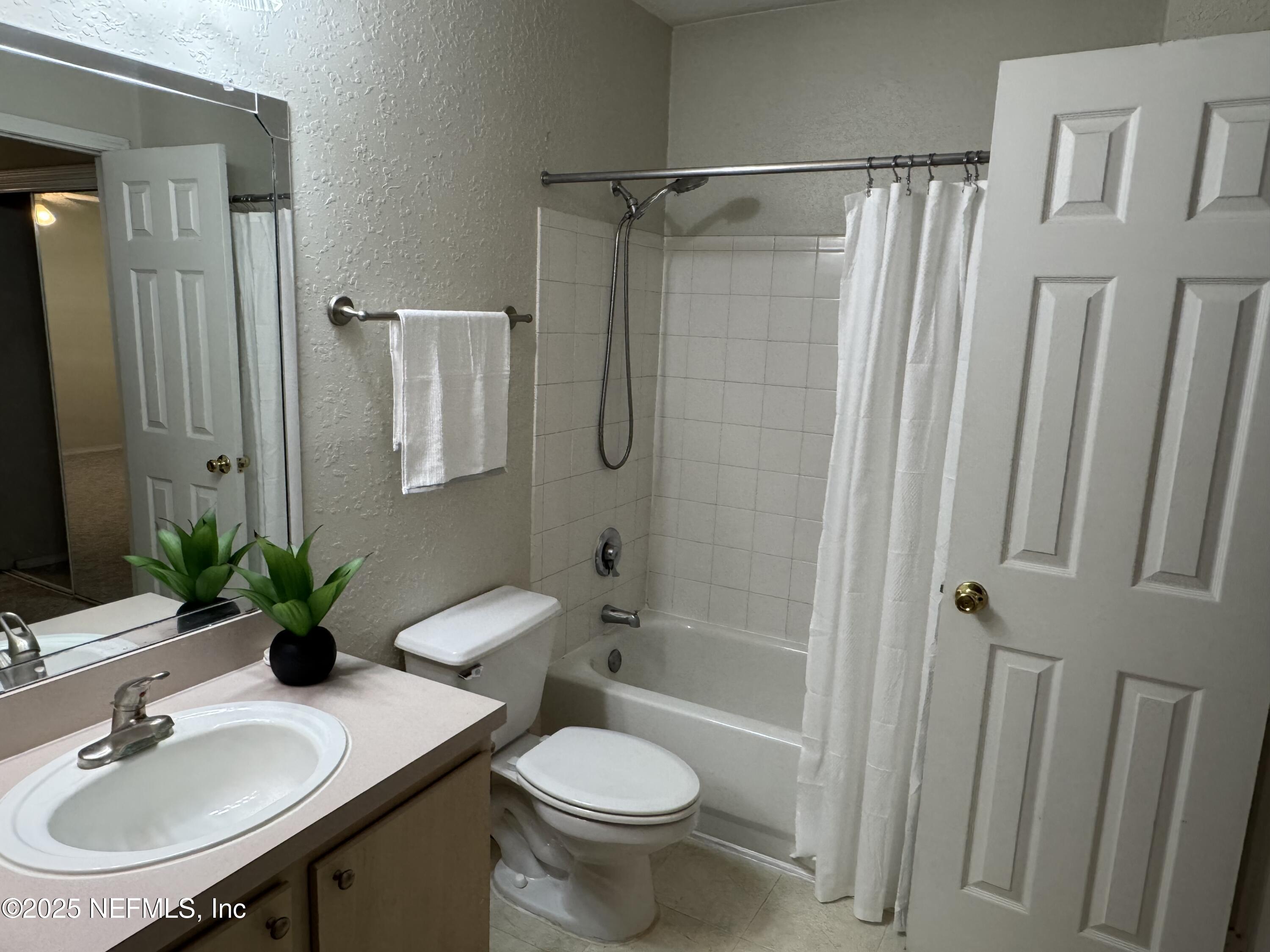 1701 The Greens Way, Unit 214 Jacksonville Beach, FL 32250 - Photo 14 of 21 a bathroom with a sink toilet and shower