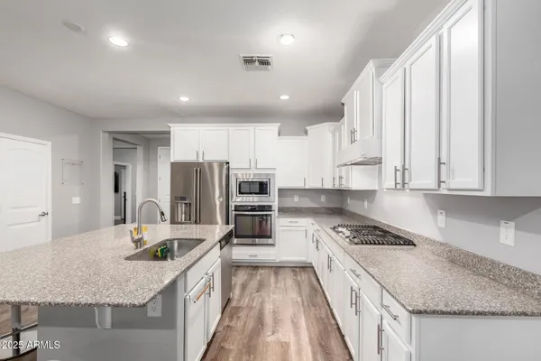 a kitchen with stainless steel appliances granite countertop a sink stove and refrigerator