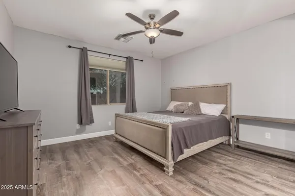 a bed sitting in a spacious bedroom next to a window