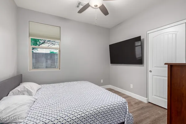 a bedroom with a bed and a flat screen tv