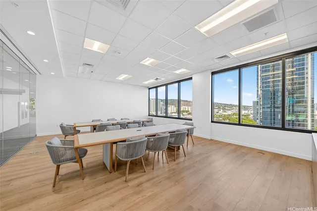 a dining hall with stainless steel appliances granite countertop a dining table chairs and large windows