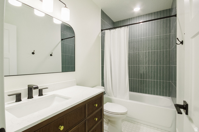 3322 250 S Street Vernal, UT 84078 - Photo 26 of 37 Bathroom featuring a dark wood vanity with fluted detailing, a white countertop, and a rectangular undermount sink with dark bronze fixtures