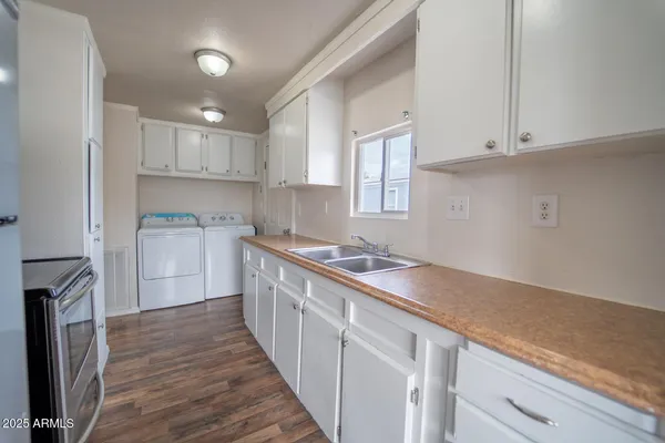 a kitchen with granite countertop a sink stove and refrigerator