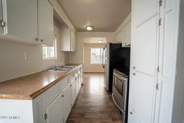 a kitchen with granite countertop a refrigerator a sink and dishwasher