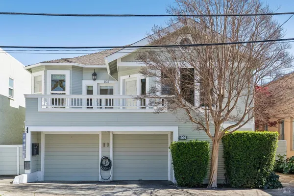 a view of an empty room with wooden floor and windows