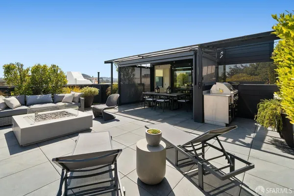 a view of a patio with couches table and chairs and potted plants
