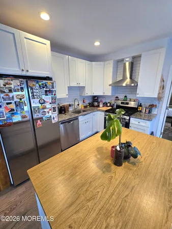 a kitchen with stainless steel appliances granite countertop a sink refrigerator and microwave
