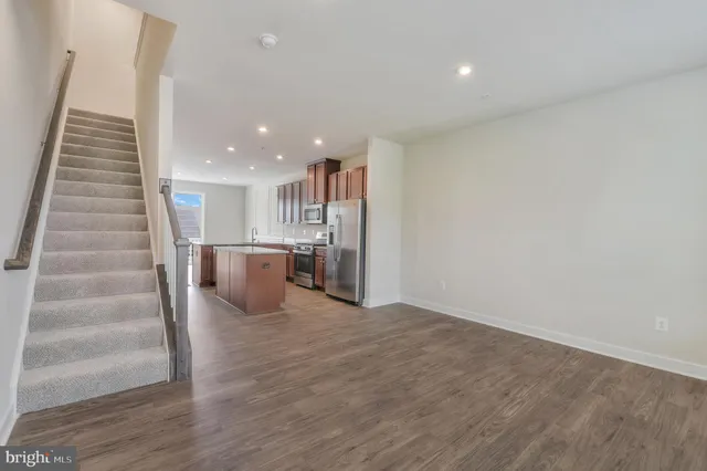 a view of an empty room and a kitchen